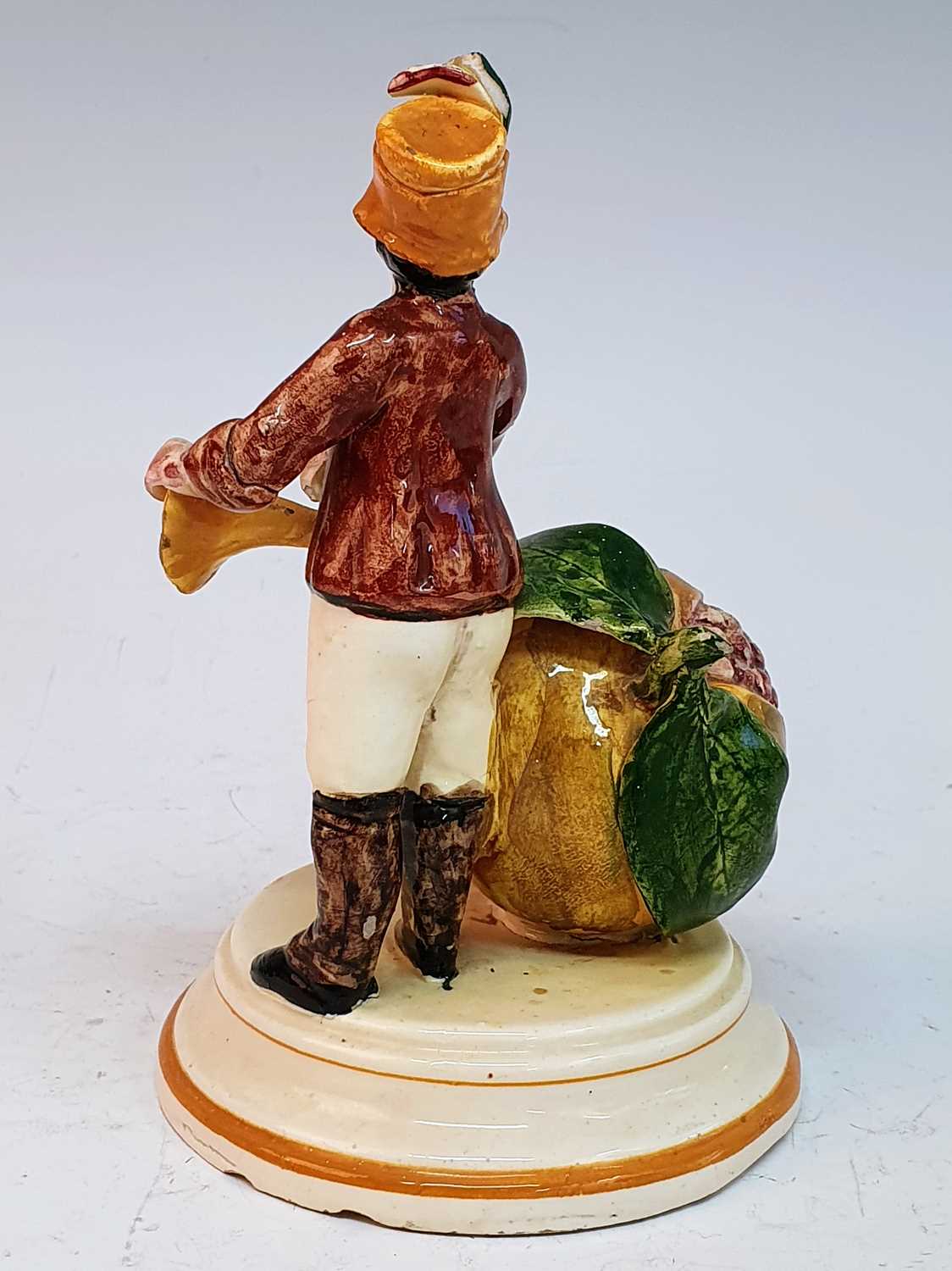 A 19th century continental cream glazed earthenware moneybox, in the form of a man playing a horn - Image 4 of 5