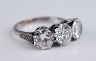 A white metal diamond three stone ring, comprising three round brilliant cut diamonds in claw