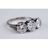 A white metal diamond three stone ring, comprising three round brilliant cut diamonds in claw