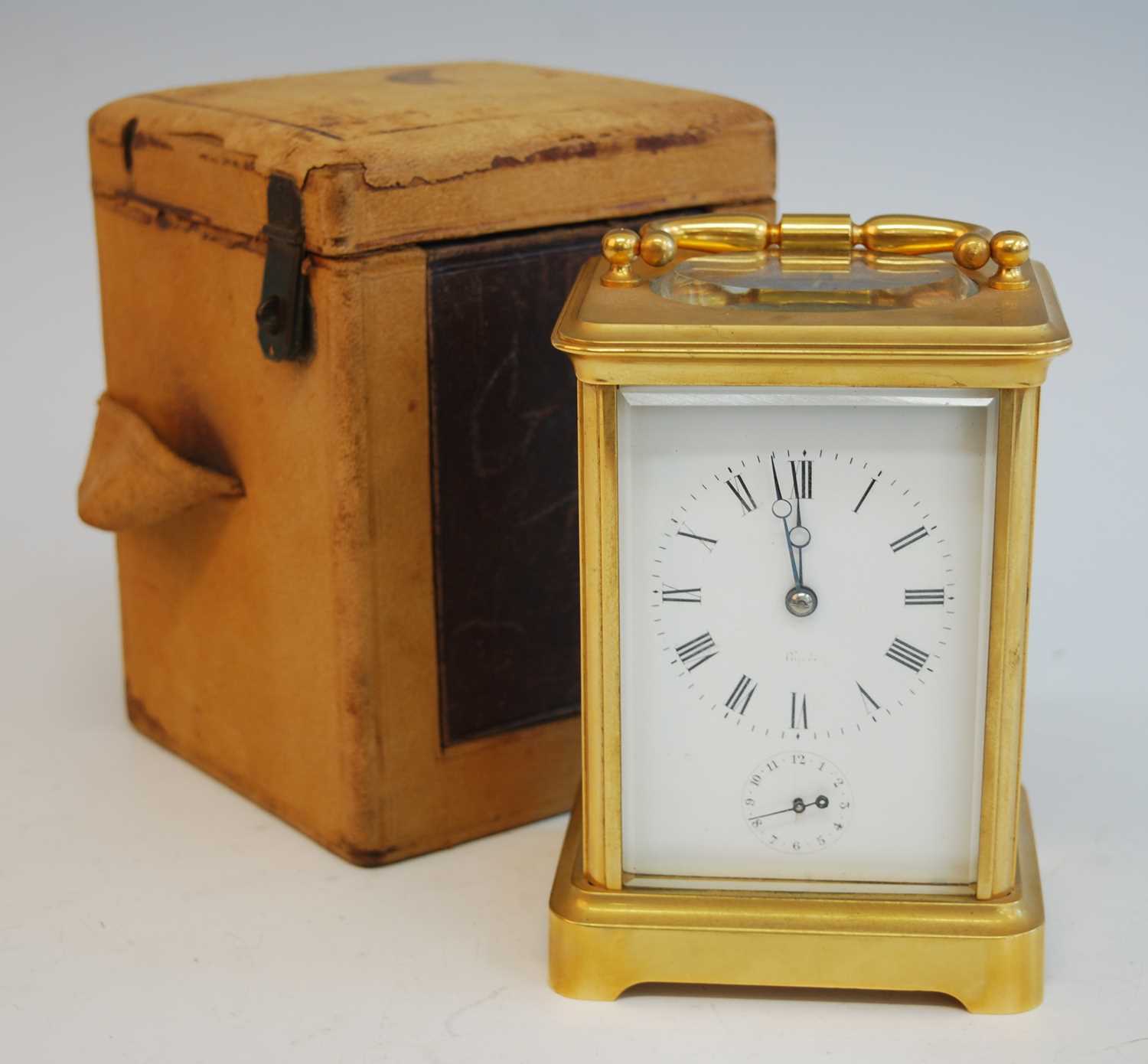 A late 19th century French lacquered brass carriage clock with alarm, having white enamel Roman dial