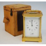 A late 19th century French lacquered brass carriage clock with alarm, having white enamel Roman dial