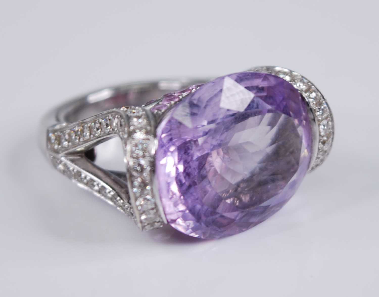 A contemporary French 18ct white gold, amethyst and diamond dress ring, arranged as a large oval cut