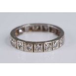 A white metal diamond set eternity ring, arranged as 20 round cuts in carved star settings, total