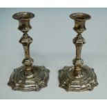 A pair of late Victorian silver table candlesticks, the knopped stems to shaped and stepped square
