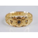 An Edwardian 18ct gold diamond three stone ring, the old round cuts each being 'gypsy' set, total