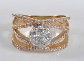 A yellow metal four-strand diamond crossover ring by Frederic Sage, featuring a centre circular