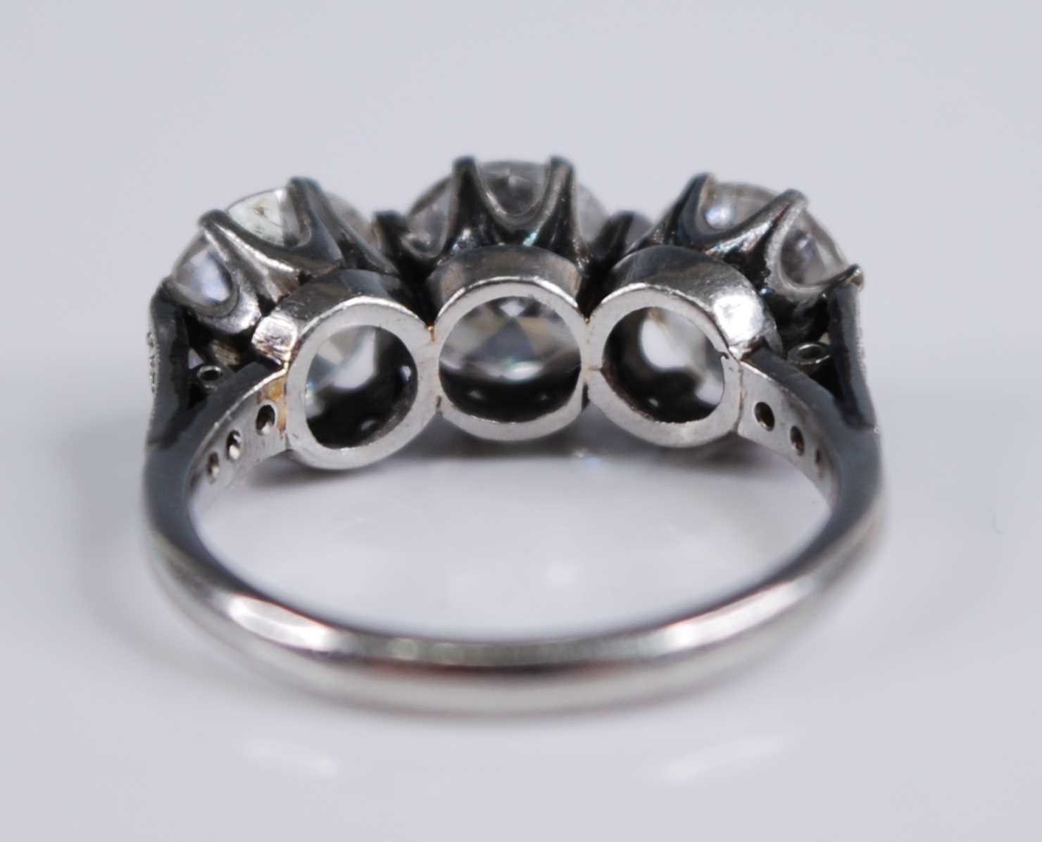 A white metal diamond three stone ring, comprising three round brilliant cut diamonds in claw - Image 5 of 7