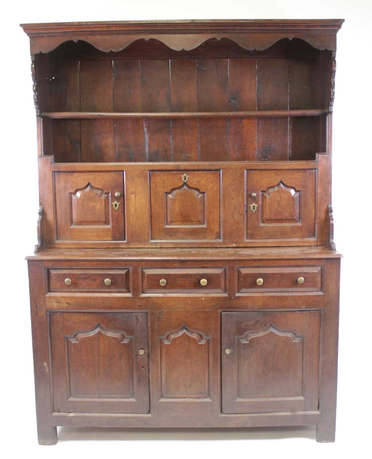A George III joined oak dresser, the upper section having a wavy frieze and two shelves above