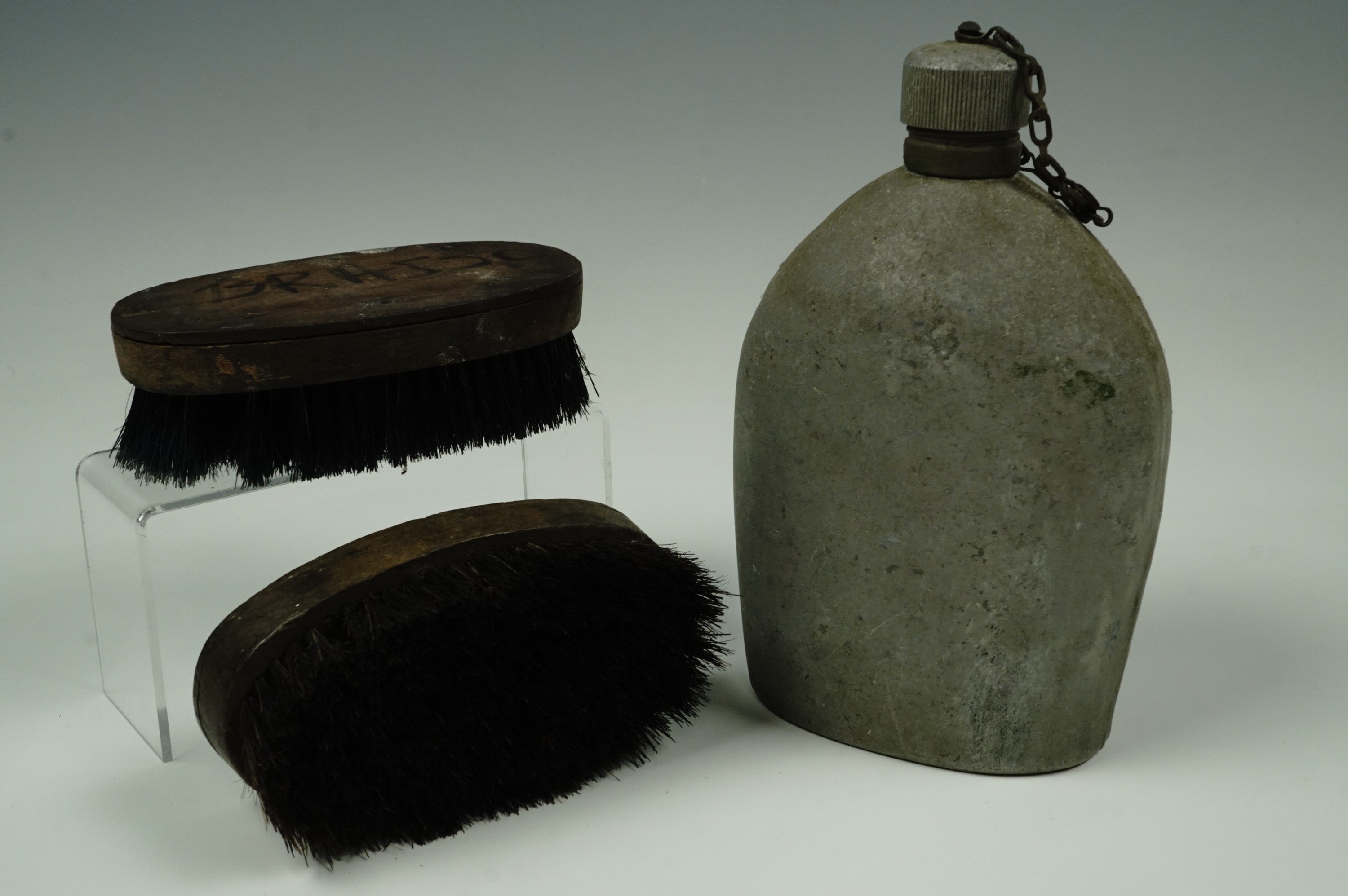 A Great War US Army water bottle together with a pair of Second World War British Army hairbrushes