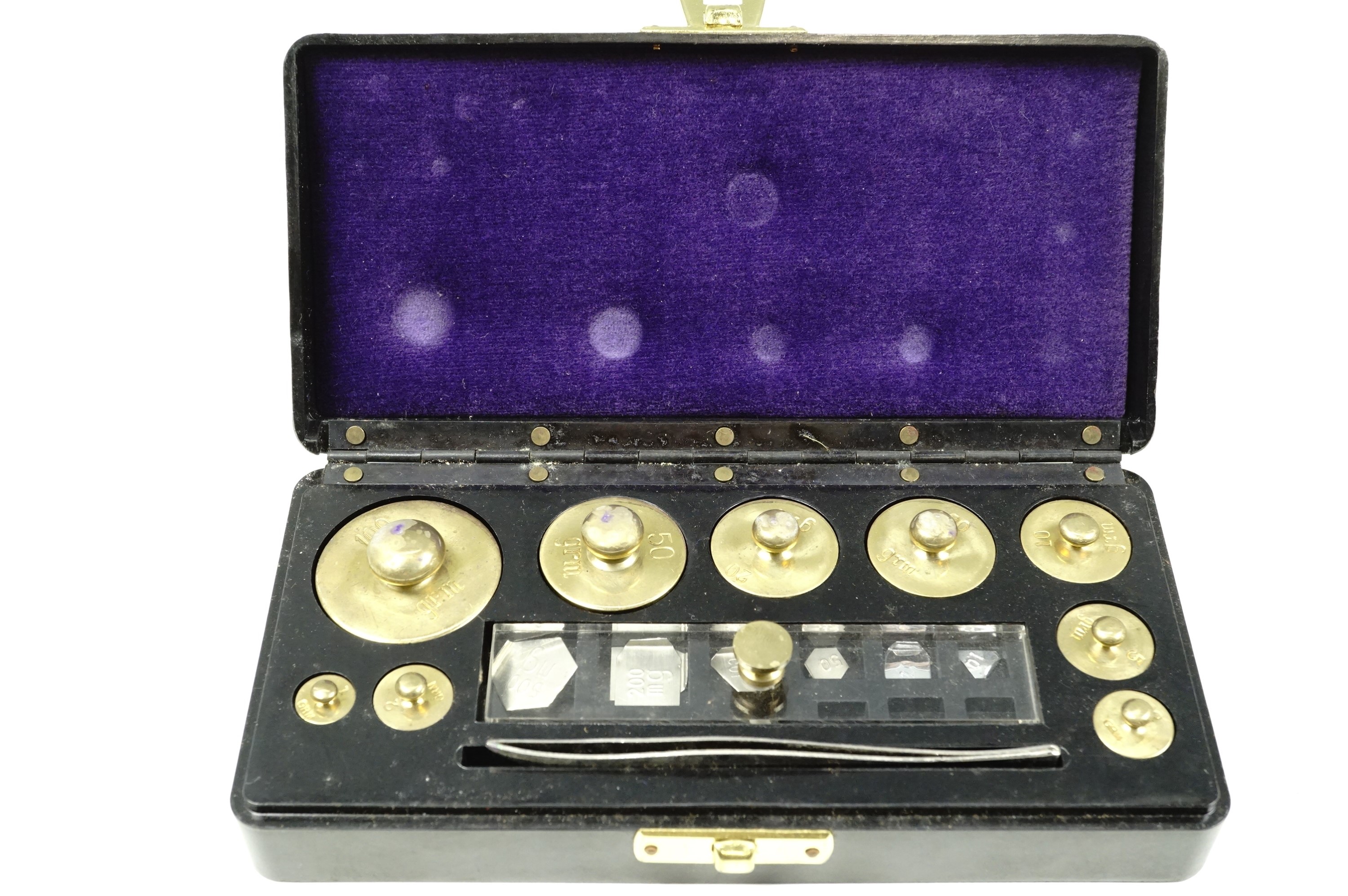 A cased set of metric brass weights