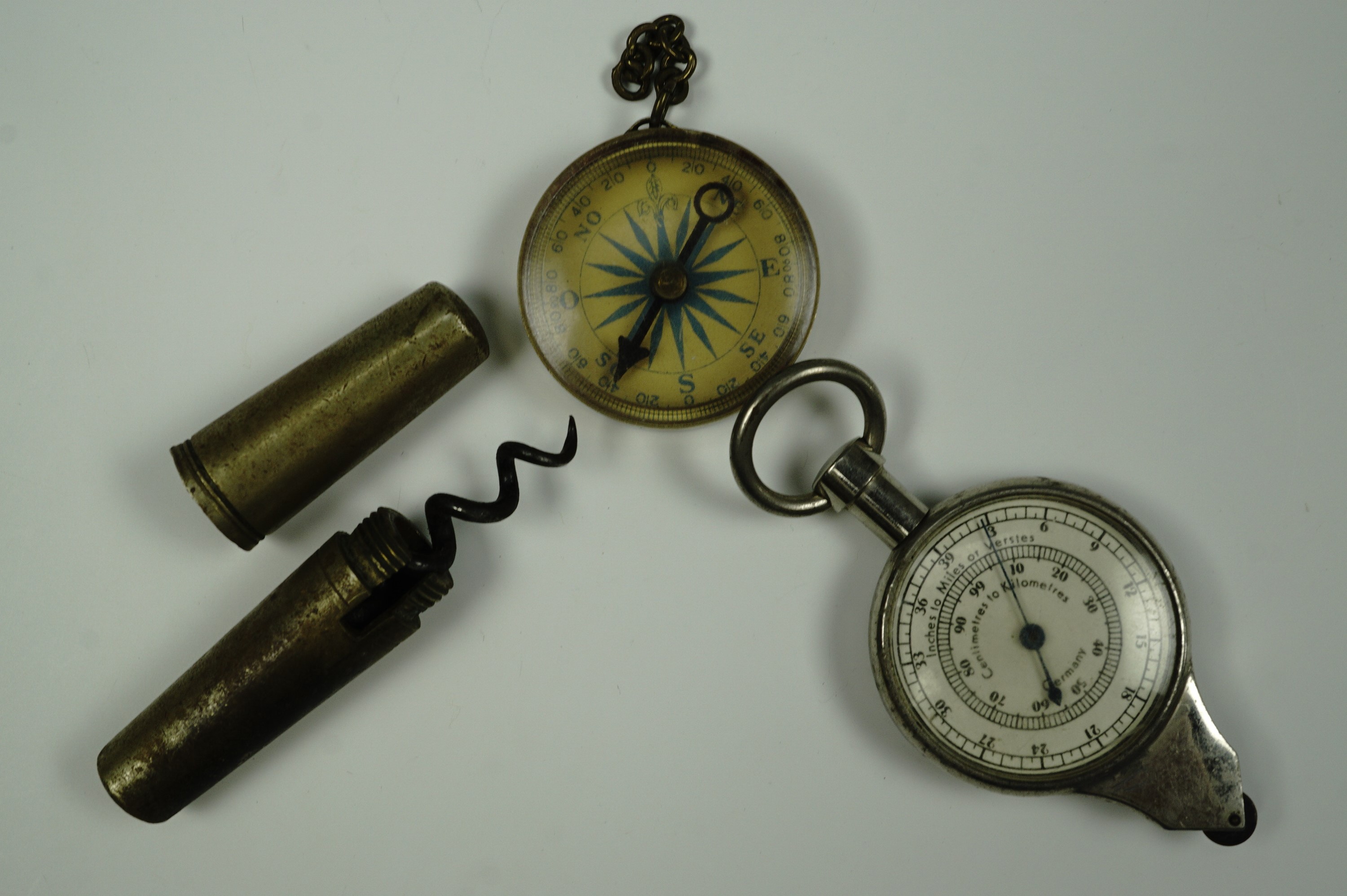 A portable brass corkscrew, map gauge and compass