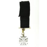 A Boer War period steel watch chain fob medallion in the form of a cross and bearing the struck