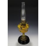 A late 19th / early 20th Century oil lamp, having a marbled glass reservoir supported on a brass