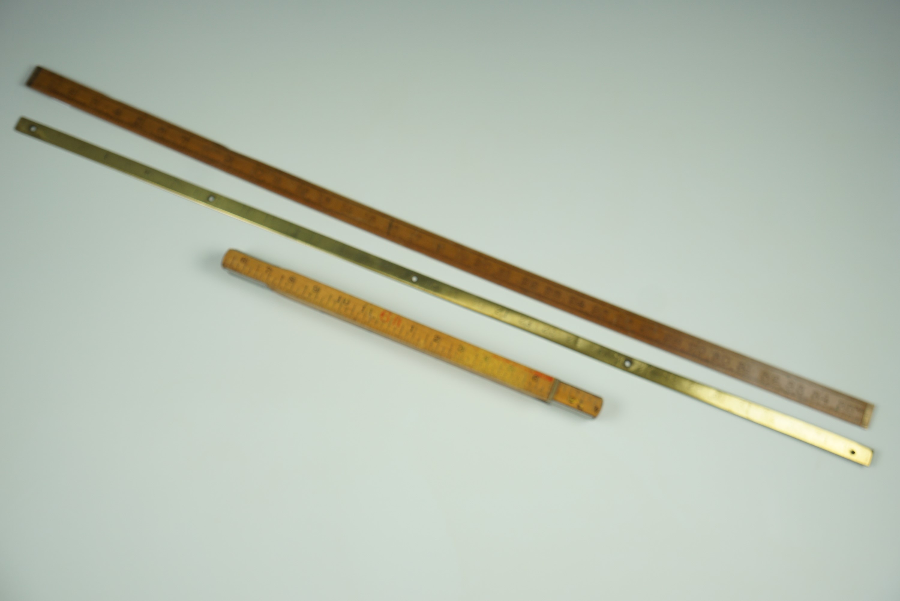 A brass yard stick, one other and a "Fisco" ruler