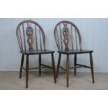 A pair of Ercol wheel back dining chairs, with Prince of Wales feathers in backsplat roundel, kite