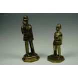 Two cast brass figures of 1980s police officers, modelled respectively standing to attention and t