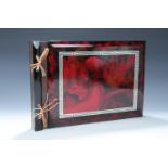 A 1950s Oriental photograph album, black lacquer with oxblood scenes and a silver key border to