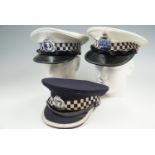 Three Australian police hats, bearing badges for "South Australia", "WA Police" and "S A Police"