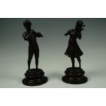 A pair of bronzed figures of musicians, bearing indistinct signatures, 26 cm