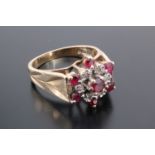 A vintage ruby and white stone cluster ring, comprising a central facet-cut ruby claw-set within a