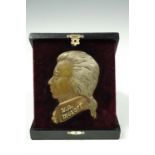 A cast brass relief profile portrait plaque depicting Mozart, 10 cm