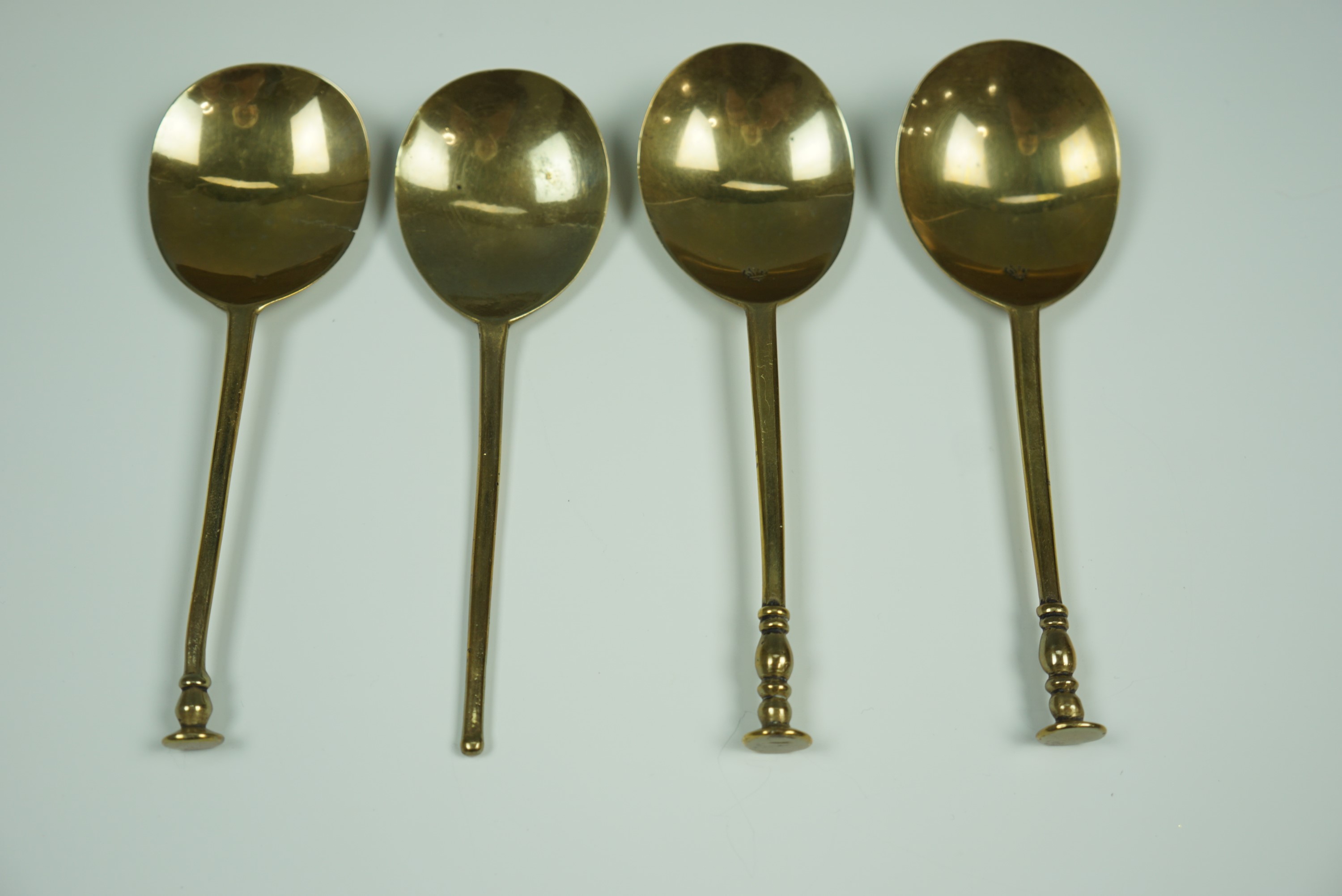 Three 16th - 17th Century style brass seal top spoons stamped to the bowls with a fleur-de-lys and a