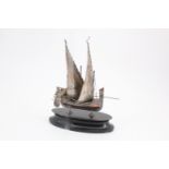 An early 20th Century Maltese white metal model dghajsa tal-pass sailing boat, on ebonised plinth,