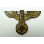 A German Third Reich eagle cap badge, pressed brass, 6 cm wide