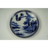 A late 19th Century Chinese blue-and-white porcelain charger, depicting an estuary with structures