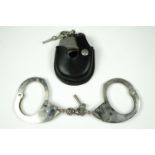 A set of Hiatt "Peerless" police handcuffs in leather belt pouch, together with a set of Hiatt's