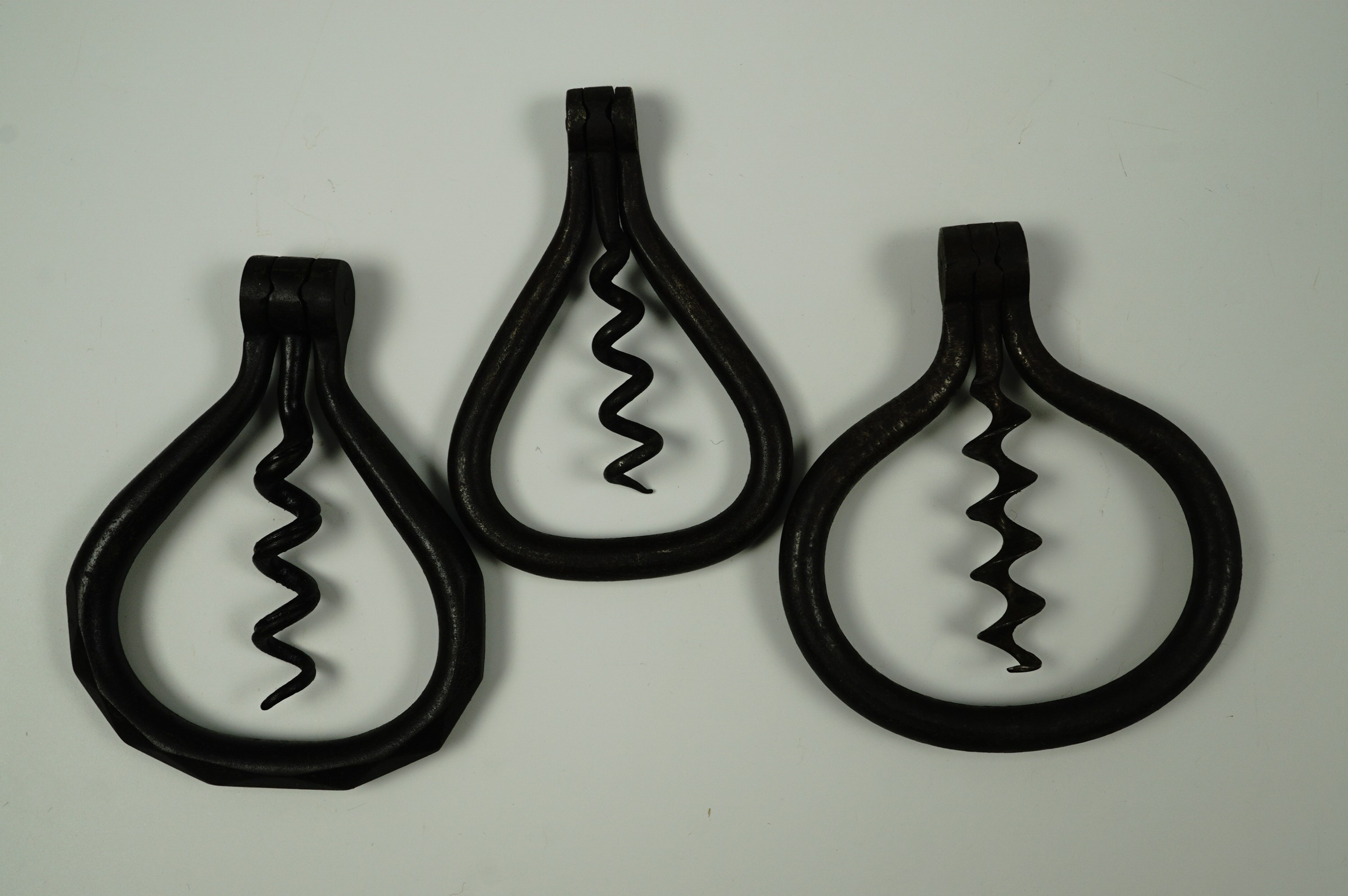 Three 19th Century folding "stirrup" corkscrews including a faceted example