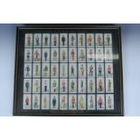 A framed set of 1930s cigarette cards "Military Uniforms of the British Empire Overseas", 42 cm x 49