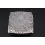 A 1920s silver cigarette case, of rounded square form, foliate scroll engraved, the obverse