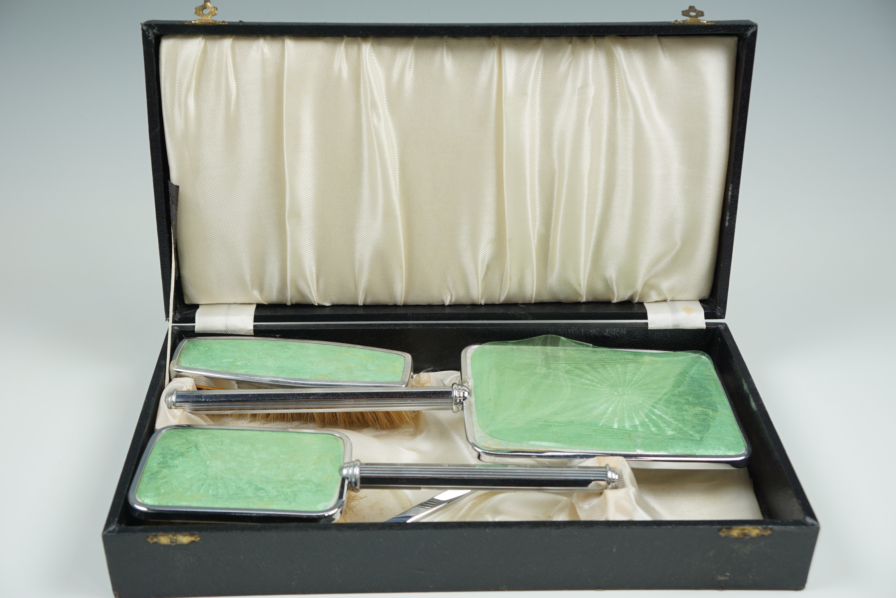 A cased dressing table set, in chrome plate and faux green guilloche enamel, circa 1940s