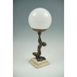 A Art Deco figural table lamp having a polished marble base and a spherical glass globe, 40 cm
