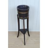 An early 20th Century brass banded coopered oak jardiniere, on a three legged stand with
