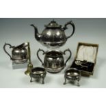 A three piece electroplate tea set together with two Georgian style salt cellars, an electroplate