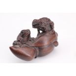 A Japanese carved wood netsuke of two frogs on a blossom, 4.5 cm