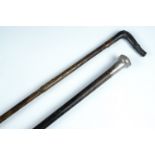 A late Victorian faux bamboo walking cane having a silver handle, together with another cane (a/f)