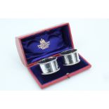 A cased pair of Victorian silver napkin rings, of plain cylindrical form with beaded edges, in a