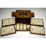 An early 20th Century brass bound hardwood chest including five draws with bone Mah Jong tiles and