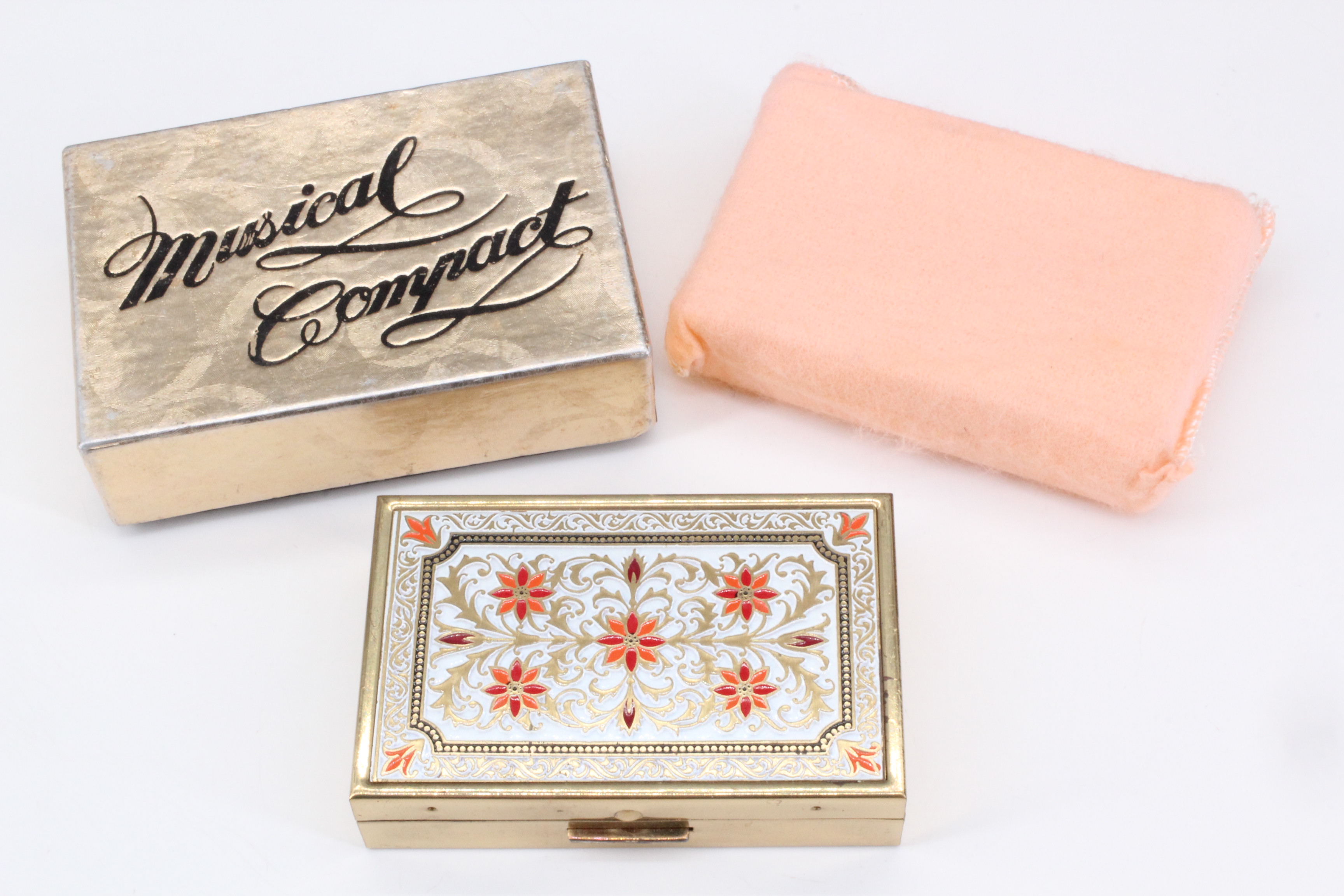A Japanese musical compact, in its original box and protective cloth case, unused, 7.5 cm x 5 cm x 2