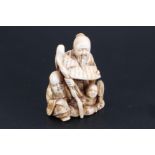 A Japanese ivory netsuke of two dignitaries with a child, 4.5 cm