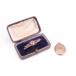 An Edwardian 9 ct gold brooch in its fitted case, having a central roundel set with garnet on two