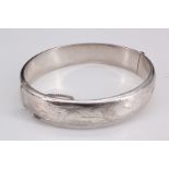 An Edwardian influenced silver bracelet, being of a hollow D shape, having bright cut reticulated