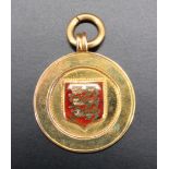 An enamelled 9 ct gold medal, bearing a shield enamelled with three golden lions in a red field with