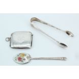 A silver vesta case, Birmingham, 1938, together with silver sugar tongs, Sheffield, 1939, and an