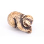 A Japanese stag horn netsuke of a crouching monkey with inlaid eyes, 3.5 cm