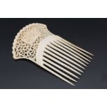 An early 20th Century carved ivory hair comb, the top being profusely pierced with scrolls