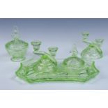 A five-piece pressed uranium glass dressing table set